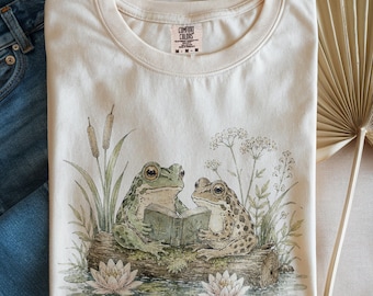 Maglietta accogliente con rana e topo di biblioteca, maglietta estetica con rospo che legge, maglietta stile cottagecore con tema foresta, regalo carino per amanti dei libri, top con animali dai colori comodi