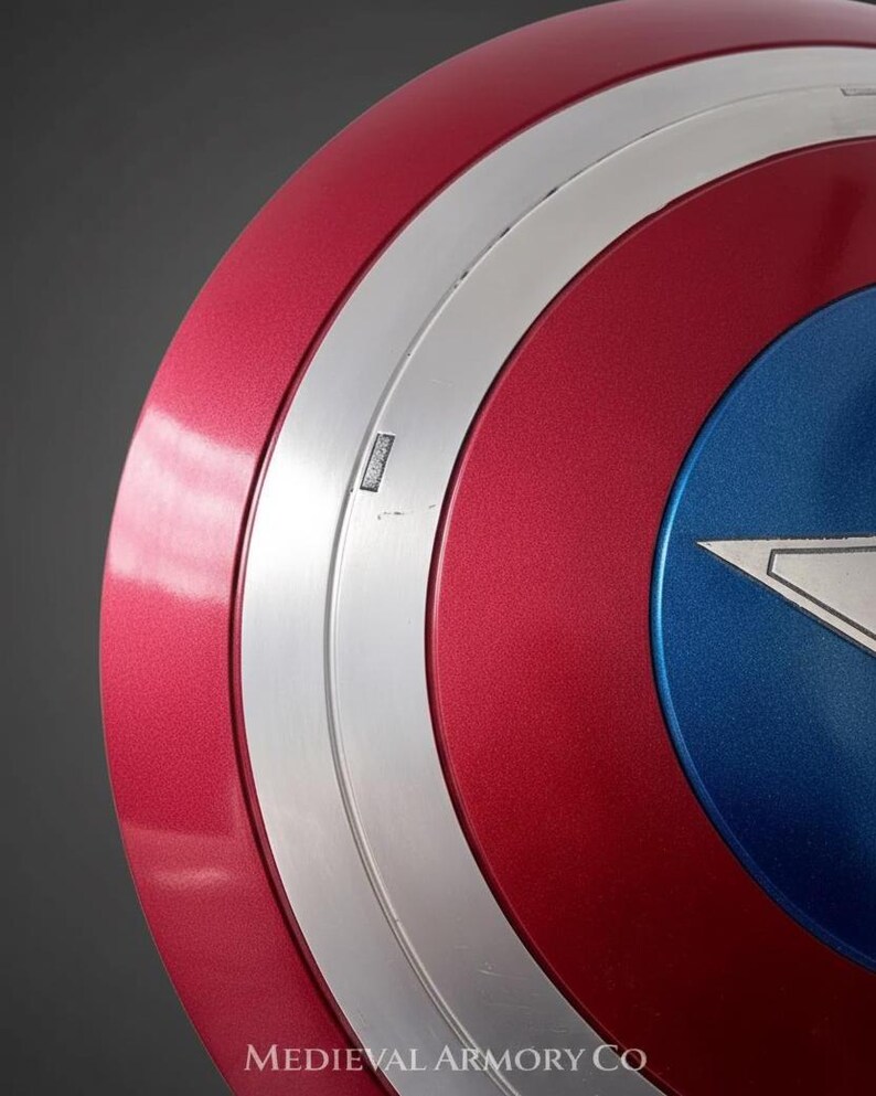 May include: A close-up of a red, white, and blue shield with a metallic finish. The shield has a circular design with a silver band and a blue star in the center. The text "MEDIEVAL ARMORY CO" is visible.