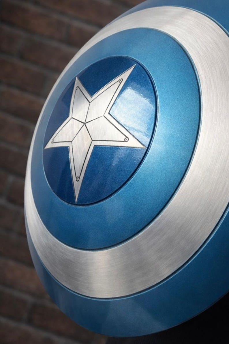 Op de afbeelding: Een close-up van een Captain America-schild. Het schild is voornamelijk blauw met een zilveren ster in het midden. Zilveren banden omcirkelen de ster en de buitenrand van het schild. Het schild heeft een metallic glans.
