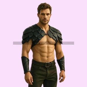 Puede incluir: Armadura de hombro de cuero negro con un diseño en forma de hoja, combinada con brazaletes a juego. La armadura se asegura con una hebilla y un cierre de anillo. El modelo lleva pantalones negros y un cinturón negro.