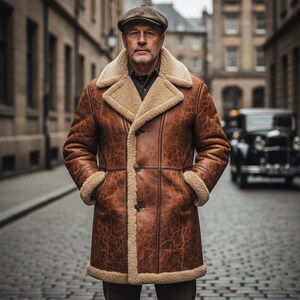 May include: A brown leather coat with a shearling collar and lining. The coat has a button-up front and pockets. The person in the image is wearing a brown tweed cap. The background shows a cobblestone street and buildings.