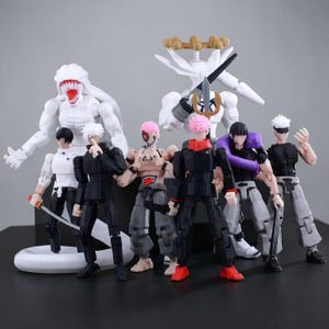 May include: A collection of seven articulated action figures featuring various characters in black, white, grey, and pink outfits. The group includes two large white monster figures, one with a sword, and five human-like figures with swords and accessories.