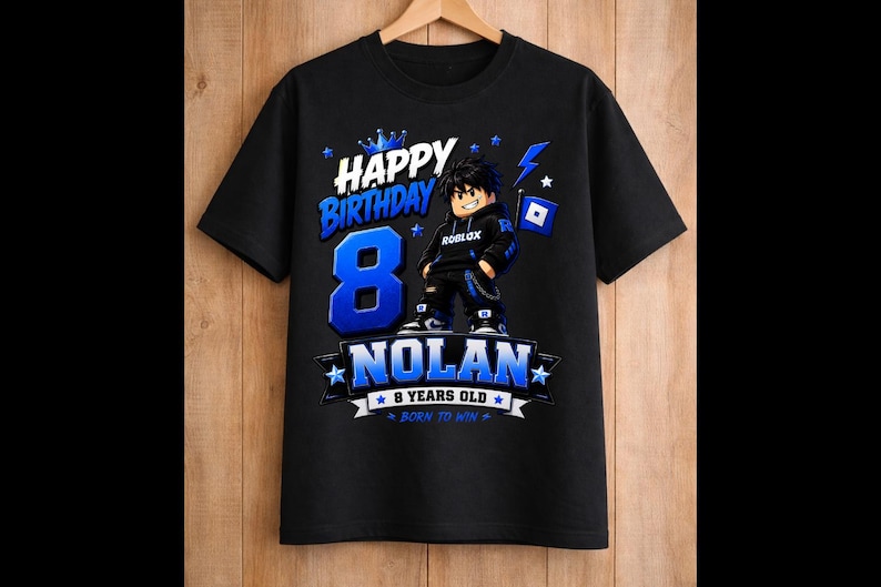 May include: Black t-shirt with a blue and white graphic design. The design includes the words "Happy Birthday" and "Nolan", along with the number "8" and a Roblox character. The shirt also says "8 years old" and "Born to Win".