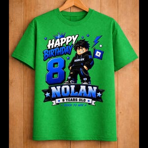 May include: Green t-shirt with a graphic featuring a Roblox character, the number 8, and the name "Nolan." Text includes "Happy Birthday," "8 Years Old," and "Born to Win." The design is in blue and white.