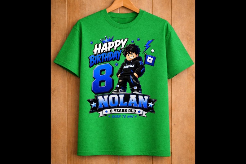 May include: Green t-shirt with a graphic featuring a Roblox character, the number 8, and the name "Nolan." Text includes "Happy Birthday," "8 Years Old," and "Born to Win." The design is in blue and white.