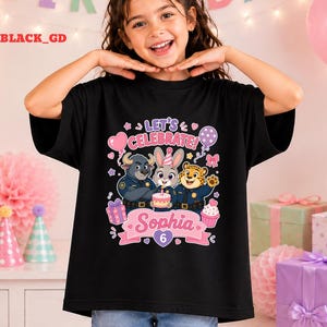 May include: Black t-shirt featuring a colorful graphic of Zootopia characters, a birthday cake, and the text "Let's Celebrate Sophia 6". The design includes a pink banner and various party-themed elements.