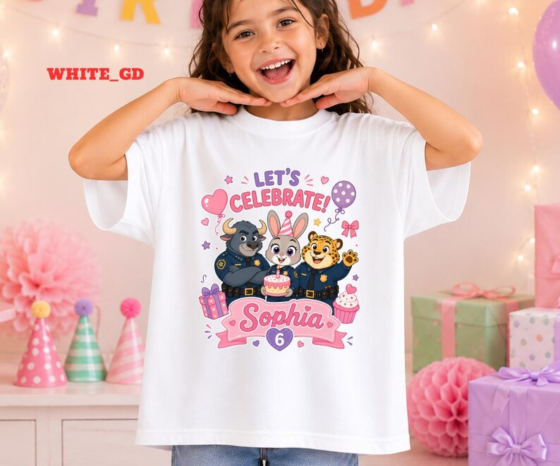 May include: White t-shirt featuring a colorful graphic of cartoon characters, a cake, and the text "LET'S CELEBRATE!" and "Sophia 6". The design includes a heart, stars, and a balloon. The shirt is worn by a young girl.