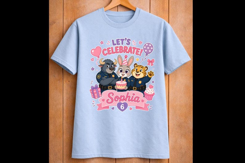 May include: Light blue t-shirt featuring a colorful graphic with three cartoon animal characters in police uniforms. The design includes the text "LET'S CELEBRATE!" and "Sophia 6" with birthday-themed elements like balloons, a cake, and cupcakes.