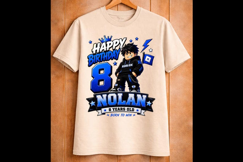 May include: A beige t-shirt with a blue and black graphic design. The design includes the words "HAPPY BIRTHDAY" above a large blue number "8", the name "NOLAN", and the phrase "8 YEARS OLD". A cartoon character is also featured.