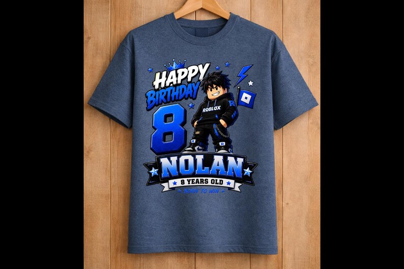 May include: Blue t-shirt with a birthday theme. The shirt features the text "Happy Birthday" and the number "8" in blue. A cartoon character is in the center, with the name "Nolan" below. The shirt also says "8 years old".