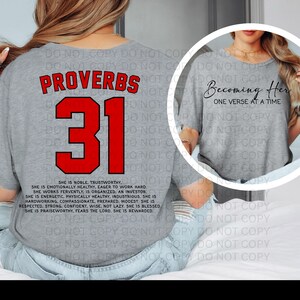 May include: A light gray t-shirt with the text "Proverbs 31" in red and black. Below the number 31, a list of qualities is printed in black. The shirt also has the text "Becoming Her, One Verse at a Time."