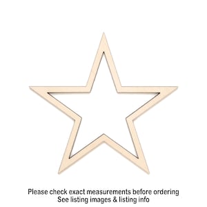 Puede incluir: Un recorte de madera de color claro en forma de estrella con el centro hueco, que presenta cinco puntas afiladas y una superficie plana y lisa. El texto debajo dice: Please check exact measurements before ordering. See listing images & listing info.