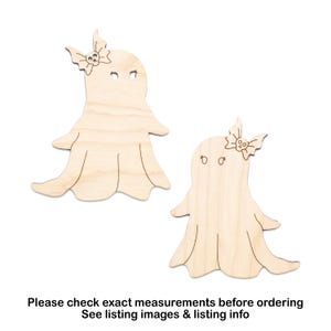 May include: Two wooden ghost cutouts with a bow and skull detail. The ghosts have eye cutouts and flowing bottom edges. The wood is a light, natural color. Text at the bottom reads: Please check exact measurements before ordering. See listing images & listing info.