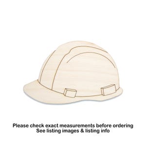 May include: A wooden cutout of a construction hard hat. The hard hat is light-colored with etched lines and rectangular details. The text at the bottom says, "Please check exact measurements before ordering. See listing images & listing info."