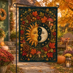 Peut inclure: Un drapeau de jardin rectangulaire présentant une illustration circulaire centrale d'un visage de soleil et de lune entouré de feuillage d'automne, de pommes de pin, de baies rouges et de champignons sur un fond sombre, suspendu à un support en métal.