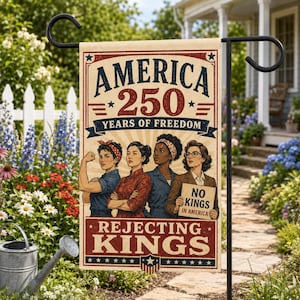 Pode incluir: Uma bandeira de jardim retangular com fundo creme e bordas e texto em vermelho e azul. O texto diz AMERICA 250 YEARS OF FREEDOM e REJECTING KINGS. Estão representadas quatro mulheres, uma flexionando o braço e outra segurando uma placa.
