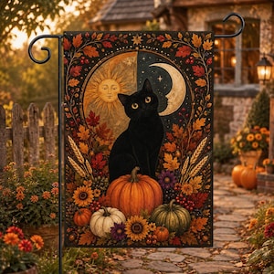 Pode incluir: Uma bandeira de jardim retangular com um gato preto sentado sobre uma grande abóbora laranja. O fundo exibe um sol e uma lua crescente, rodeados por folhas de outono, talos de trigo, girassóis e abóboras menores em tons de laranja, verde e branco.