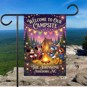 May include: A rectangular garden flag featuring a nighttime camping scene with Mickey Mouse, Minnie Mouse, Donald Duck, Goofy, and Pluto around a campfire. The text reads Welcome to Our Campsite, The Johnsons, and Asheboro, NC, under string lights.