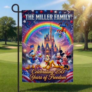 May include: A garden flag with a colourful Disney-themed illustration, a rainbow, and a castle. The flag displays "The Miller Family" and "Celebrating 250 Years of Freedom" with an American flag design. The flag is mounted on a black metal stand.