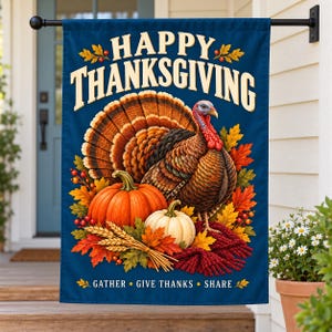 Puede incluir: Una bandera de jardín rectangular con fondo azul oscuro que muestra un pavo, calabazas naranjas y blancas, tallos de trigo y hojas de otoño. El texto dice HAPPY THANKSGIVING arriba y GATHER GIVE THANKS SHARE abajo.
