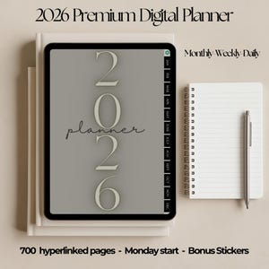 May include: A digital planner for 2026 is displayed on a tablet, with the text "2026 Premium Digital Planner." A notebook and pen are next to the tablet. The planner includes monthly, weekly, and daily views. The text "700 hyperlinked pages - Monday start - Bonus Stickers" is also visible.