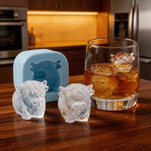 May include: A white ceramic mug with a black handle and the text "But First, Coffee" in a bold, black font. The mug is set against a neutral background, highlighting its simple design.