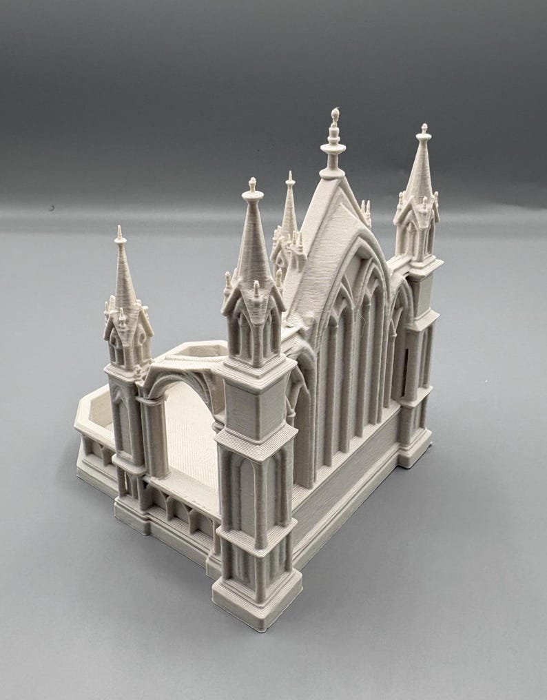 K&ouml;nnte beinhalten: Ein hellgraues Miniaturmodell einer Kathedrale mit detaillierten T&uuml;rmen, gew&ouml;lbten Fenstern und architektonischen Elementen. Das Modell hat eine rechteckige Basis und einen gew&ouml;lbten Eingang.