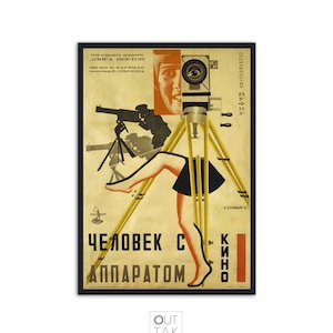 Op de afbeelding: Een vintage poster voor de Sovjetfilm "De man met de camera" uit 1929 van Dziga Vertov. De poster toont de benen van een vrouw op een statief, een camera en de titeltekst in het Russisch en in het Cyrillisch.