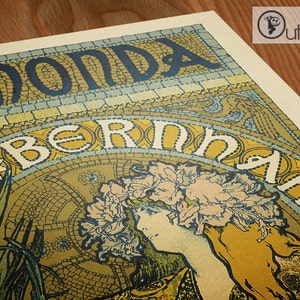May include: A vintage poster with a yellow, blue, and green color scheme. The poster features a woman with a floral crown and the text "BERNHARD MOND'A".