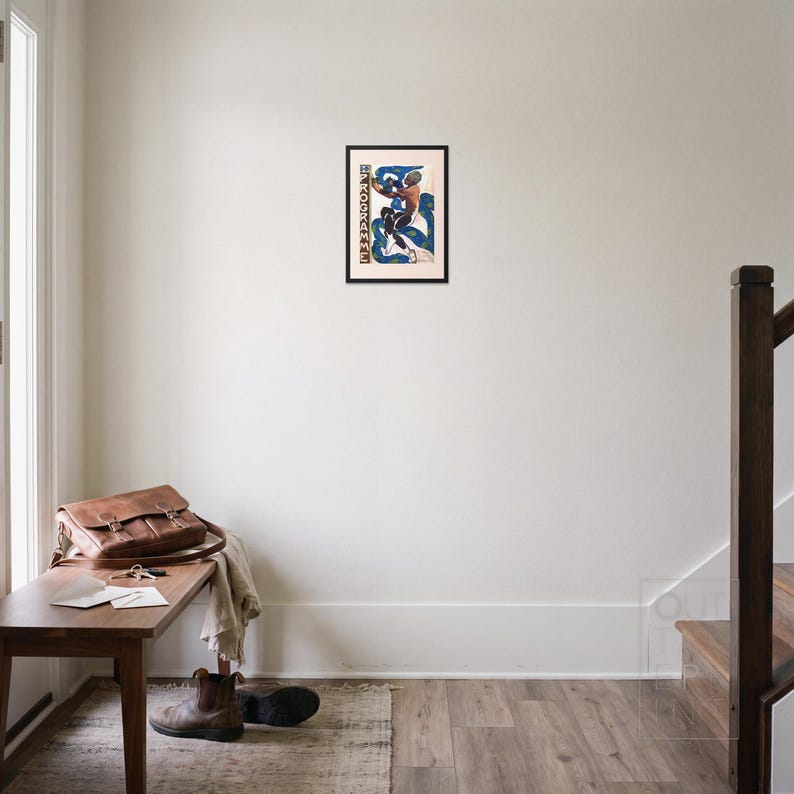 L'après framed art print, 16x22 inch, black wood frame, shown hanging in an entryway