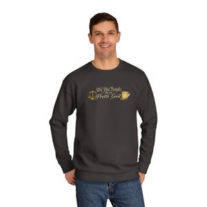 May include: Dark gray sweatshirt with the text "We The People are all Pretti Good" in gold lettering. The design includes a scale and a stack of books. The sweatshirt is a crew neck style.