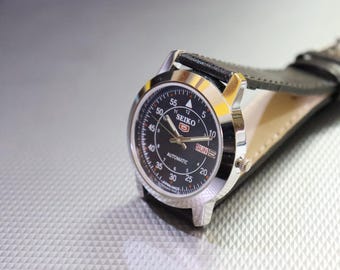 Reloj automático vintage Seiko 5, esfera negra, correa de cuero, fabricado en Japón.