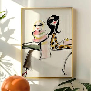 Könnte beinhalten: Ein gerahmter Kunstdruck mit einer stilisierten Tusche- und Aquarellillustration zweier Figuren in modischer Kleidung, eine davon mit Leopardenmuster-Oberteil und Sonnenbrille, auf cremefarbenem Hintergrund mit goldenem Metallrahmen.