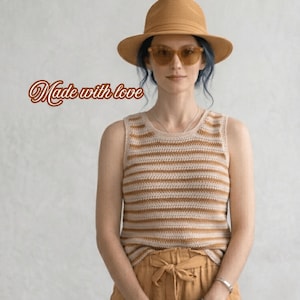 Puede incluir: Una mujer con un top de crochet beige con rayas horizontales, pantalones a juego y un sombrero de paja. La imagen incluye el texto "Made with love". También lleva gafas de sol.