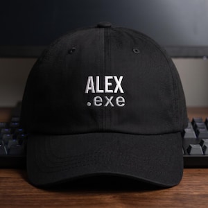 May include: A black baseball cap featuring white embroidered text on the front panel that reads ALEX .exe. The cap has a structured crown, a curved brim, and a button at the top center, showcasing a clean and simple design for everyday headwear.