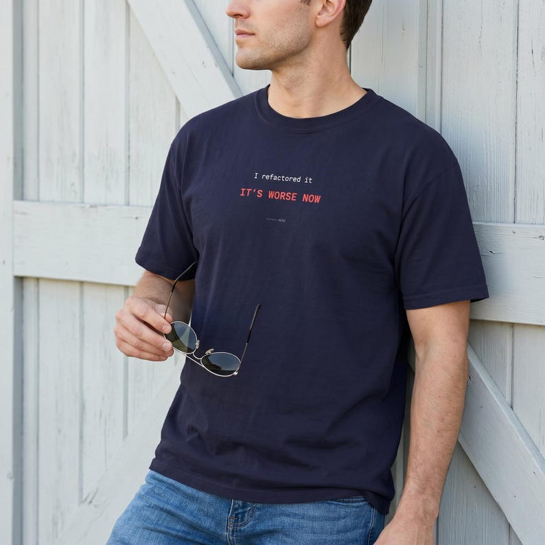 Puede incluir: Camiseta azul marino con el texto "I refactored it, IT'S WORSE NOW" en rojo y blanco. La camiseta es de cuello redondo. La persona lleva vaqueros azules y gafas de sol.