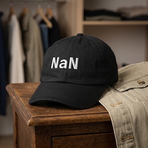 May include: A black baseball cap featuring the white embroidered text "NaN" centred on the front panel. The cap has a structured crown, a curved brim, and a button at the top, showcasing a clean design with clear, bold lettering on the front.