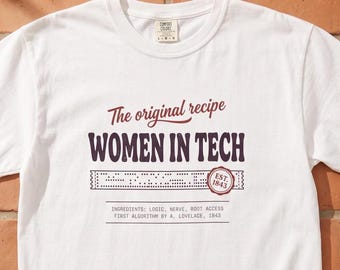 May include: A white t-shirt featuring the text The original recipe WOMEN IN TECH, a graphic of a punch card, a seal with EST. 1843, and the text INGREDIENTS: LOGIC, NERVE, ROOT ACCESS FIRST ALGORITHM BY A. LOVELACE, 1843 printed in dark red.