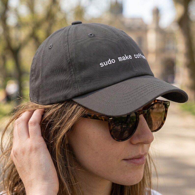 Pu&ograve; includere: Un cappellino da baseball grigio antracite con la scritta bianca "sudo make coffee". Il cappellino ha una visiera curva e un classico design a sei pannelli. Il cappello &egrave; realizzato in un tessuto morbido e resistente.