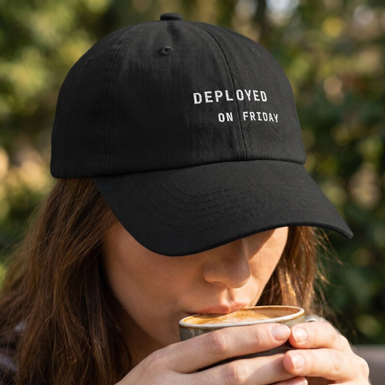 Pode incluir: Bon&eacute; de beisebol preto com a frase "DEPLOYED ON FRIDAY" bordada em branco. O bon&eacute; tem uma aba curva e um design cl&aacute;ssico de seis pain&eacute;is. Um acess&oacute;rio casual.