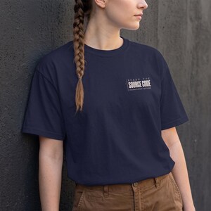 May include: A navy blue short-sleeved t-shirt featuring white text on the upper left chest that reads "READS THE SOURCE CODE" with "documentation optional" printed in smaller letters underneath the main text.