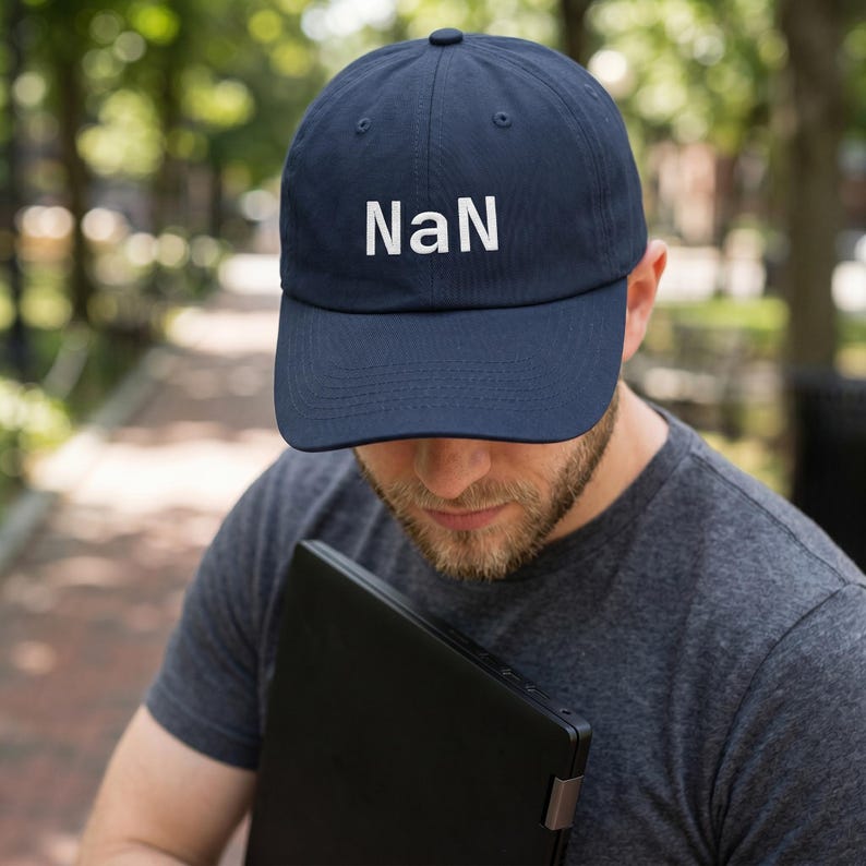 May include: A navy blue baseball cap featuring the text "NaN" embroidered in white on the front panel. The cap has a structured crown, a curved brim, and a button at the top centre. The design is simple, with the white lettering centred clearly.