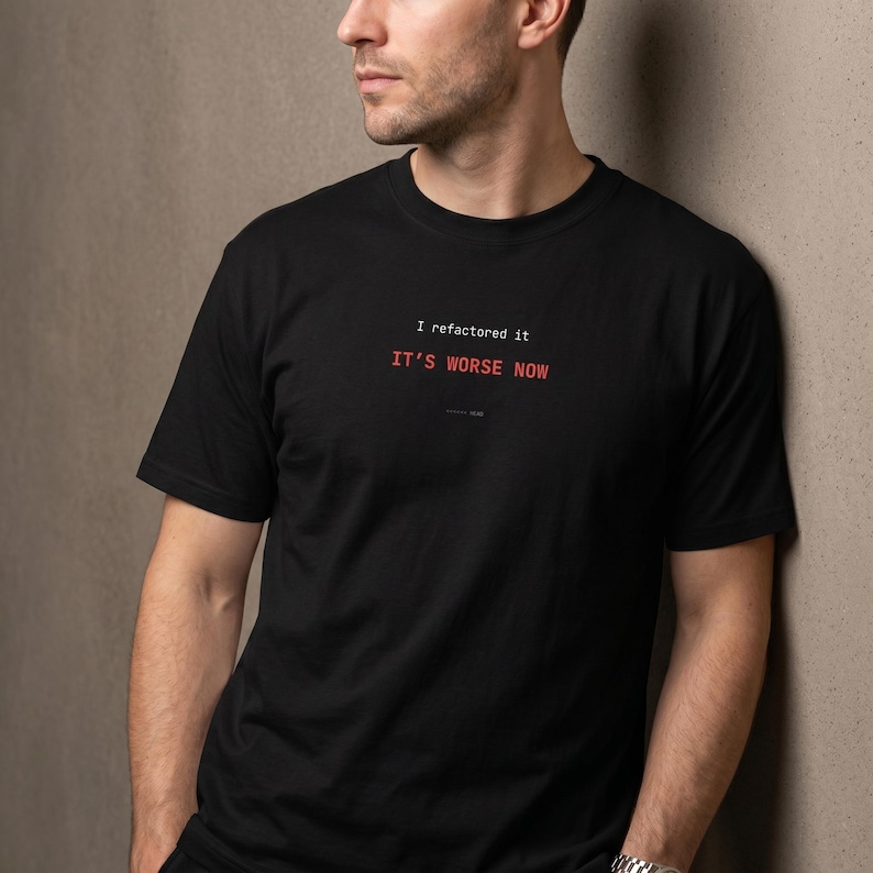 Puede incluir: Camiseta negra con el texto "I refactored it. IT'S WORSE NOW" en blanco y rojo. La camiseta es de manga corta y cuello redondo.