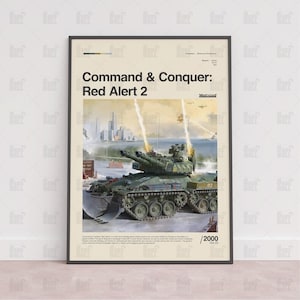 May include: Framed poster for "Command & Conquer: Red Alert 2", showing a military tank firing. The artwork includes a city skyline and is set against a beige backdrop. The frame is black.