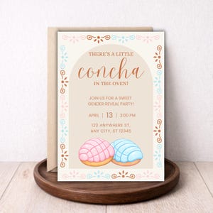 May include: A gender reveal party invitation with the text "There's a little concha in the oven!" in brown script. The invitation features a pink and a blue concha pastry illustration. The date and time are also included.