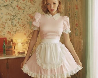 Abito da cameriera francese in raso rosa con chiusura a chiave, grembiule di pizzo e maniche a sbuffo, costume da crossdresser.