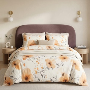 May include: A bedding set featuring a cream-colored duvet cover and matching pillowcases adorned with a watercolor-style floral pattern in shades of orange and muted gray. The set includes a solid beige rectangular accent pillow.