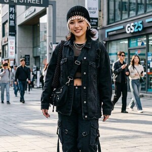 May include: A black crochet beanie with dangling white pearls, a black denim jacket, a black mesh top, black cargo trousers with side straps, and white platform trainers. A black crossbody bag with silver hardware is worn over the shoulder.
