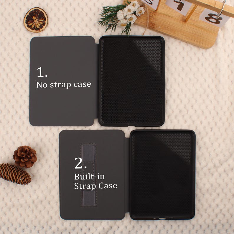 May include: Two black tablet cases are displayed, one with a strap and one without. The first case is labeled "1. No strap case" and the second is labeled "2. Built-in Strap Case". The cases are open, revealing the interior. The background is a soft, textured surface.