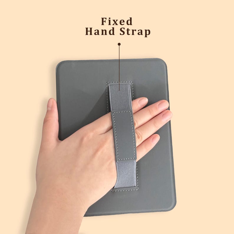 May include: A gray tablet case with a fixed hand strap. The text "Fixed Hand Strap" is above the strap. The case is rectangular with rounded corners. The hand strap is gray and elastic.